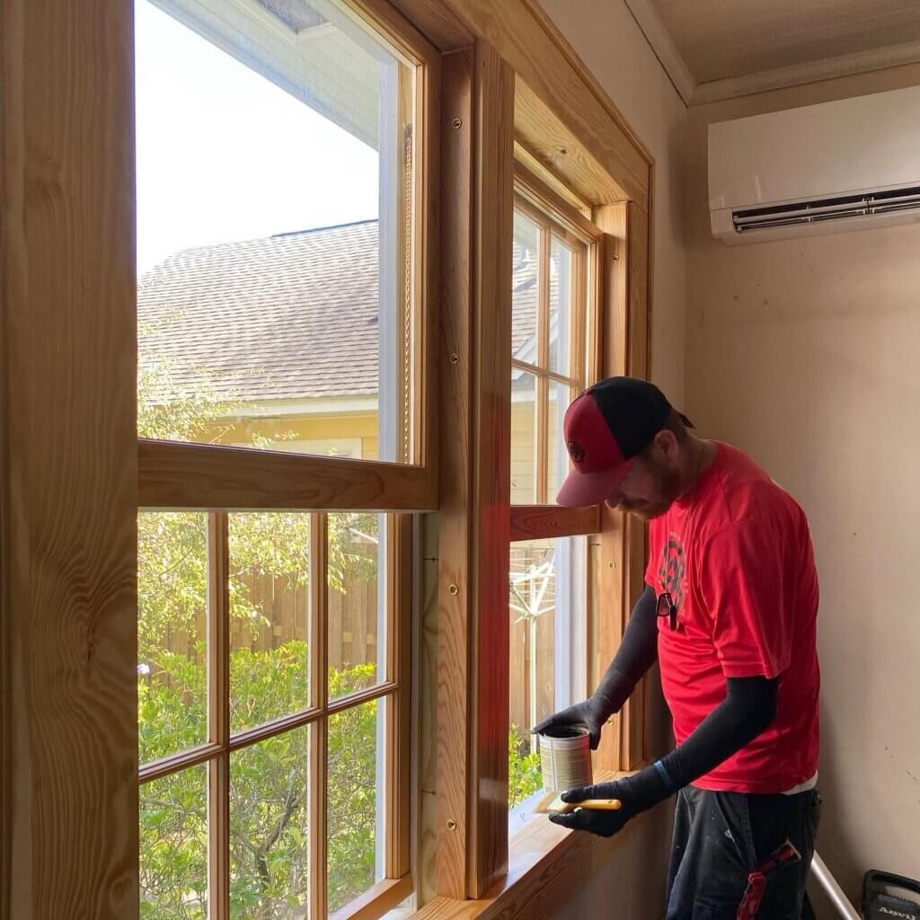 Finisher applying clear finish to a restored window