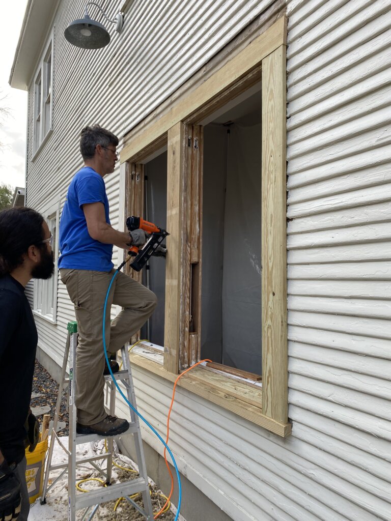 Carpenter replaces a piece of the casing on a wood window. 